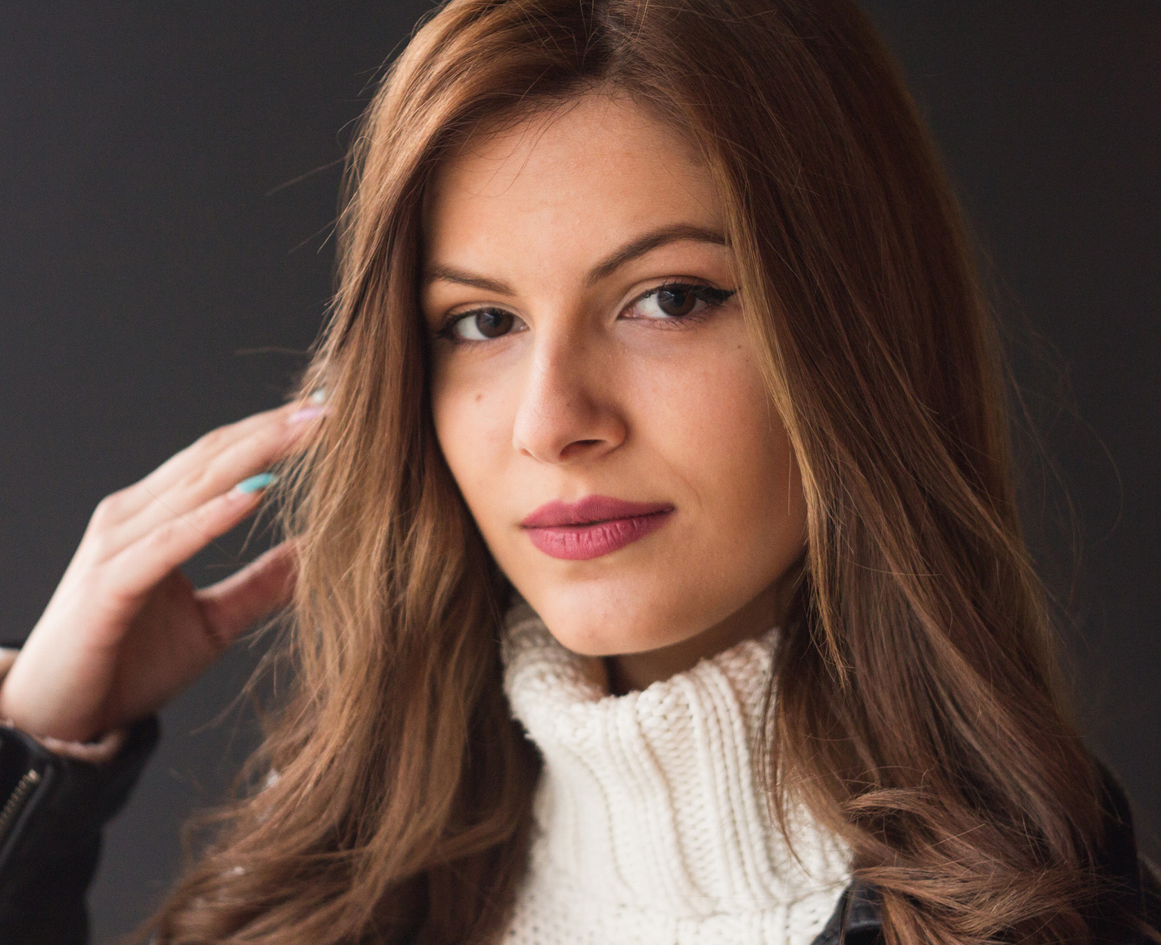 woman with long brown hair wearing a white turtleneck