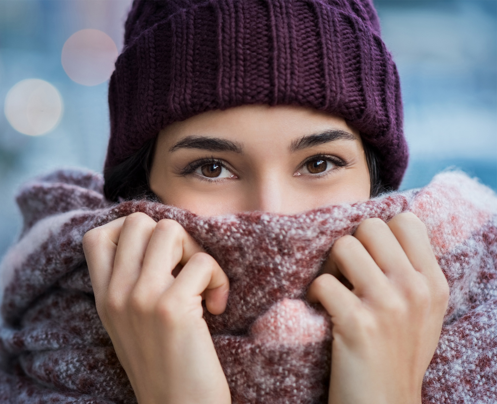 woman wearing a purple hat and scarf covering her face