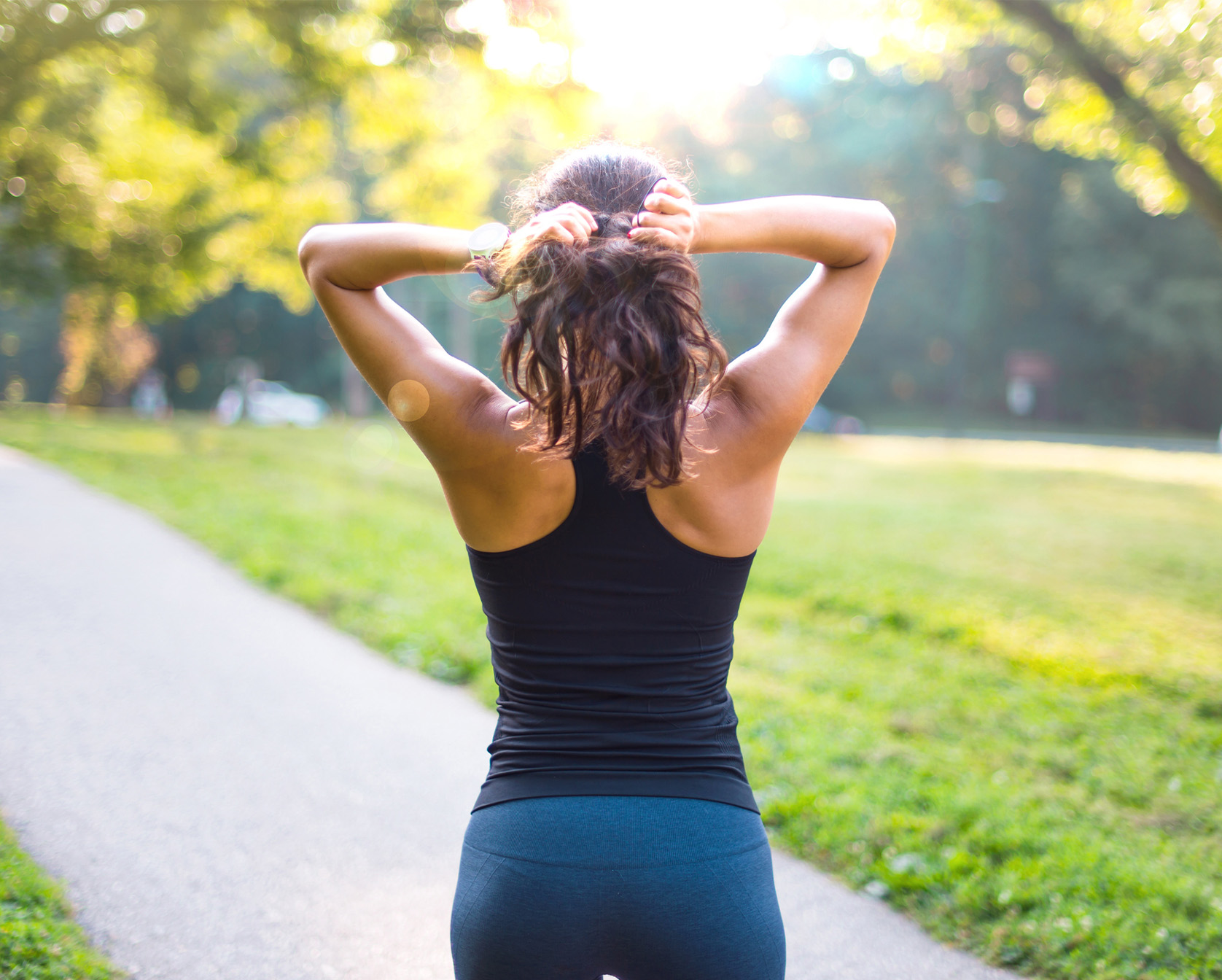 Woman standing in workout clothes with her back to the camera