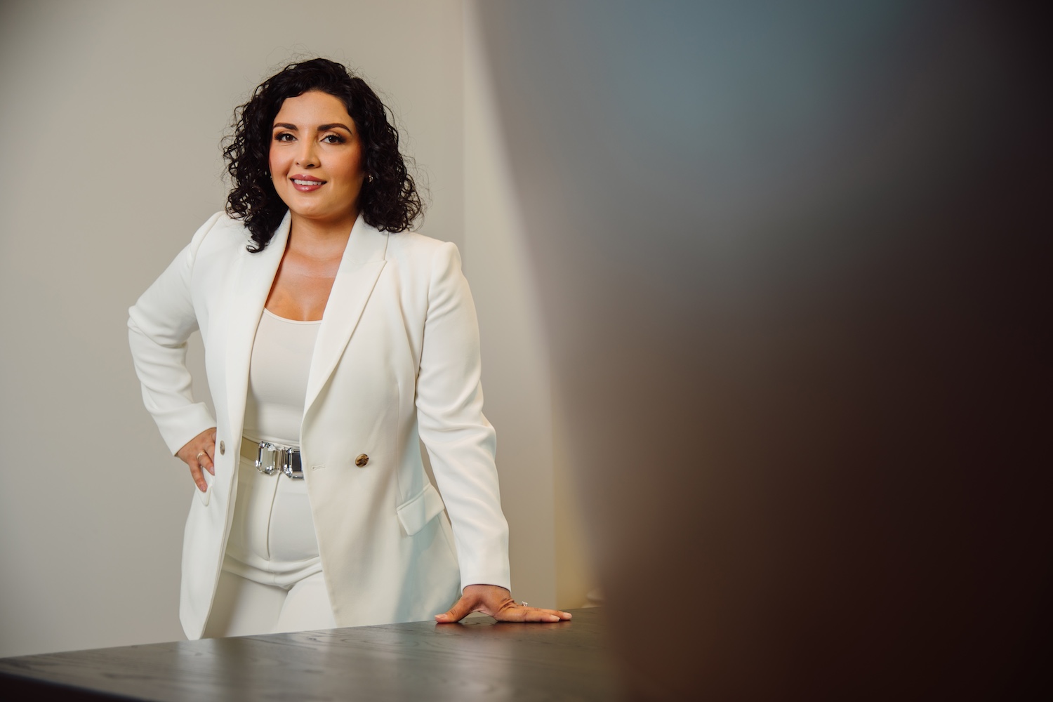 Dr. Lily Daniali in white suit standing behind table